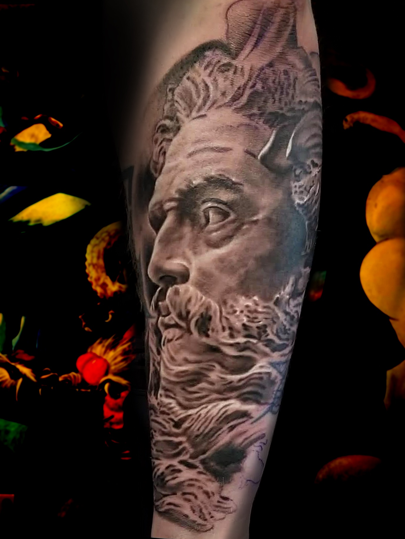 Black and grey realism forearm tattoo of a marble statue of a bearded god in profile