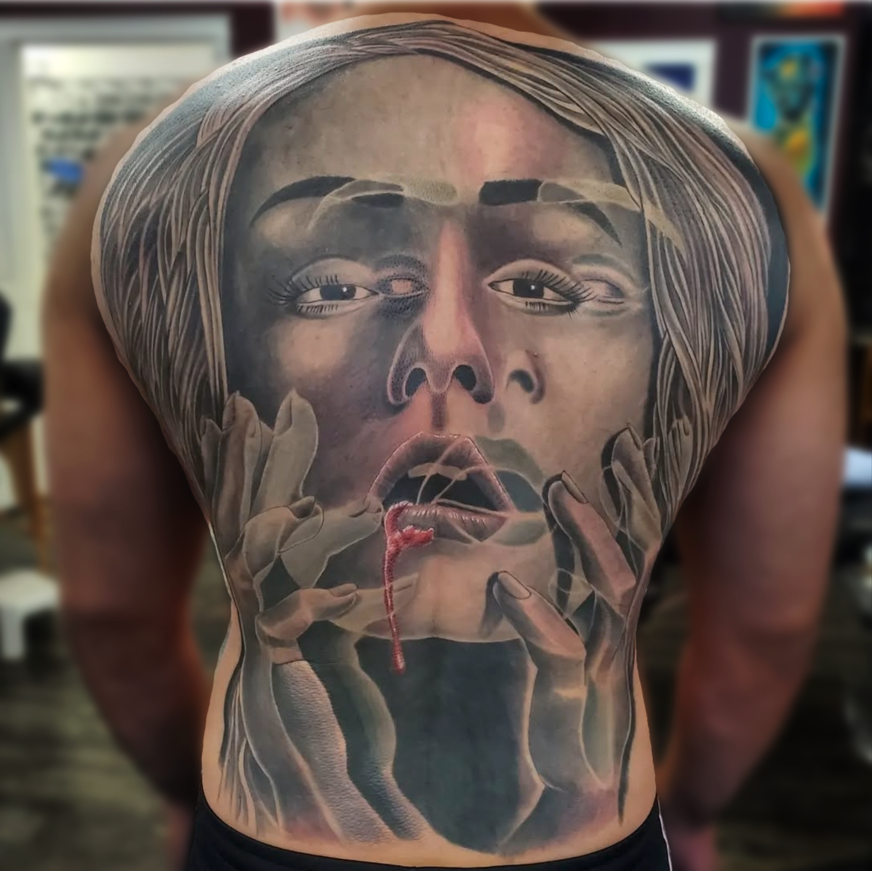 Large scale black and grey realism back piece of a woman's face with hands and a bleeding mouth
